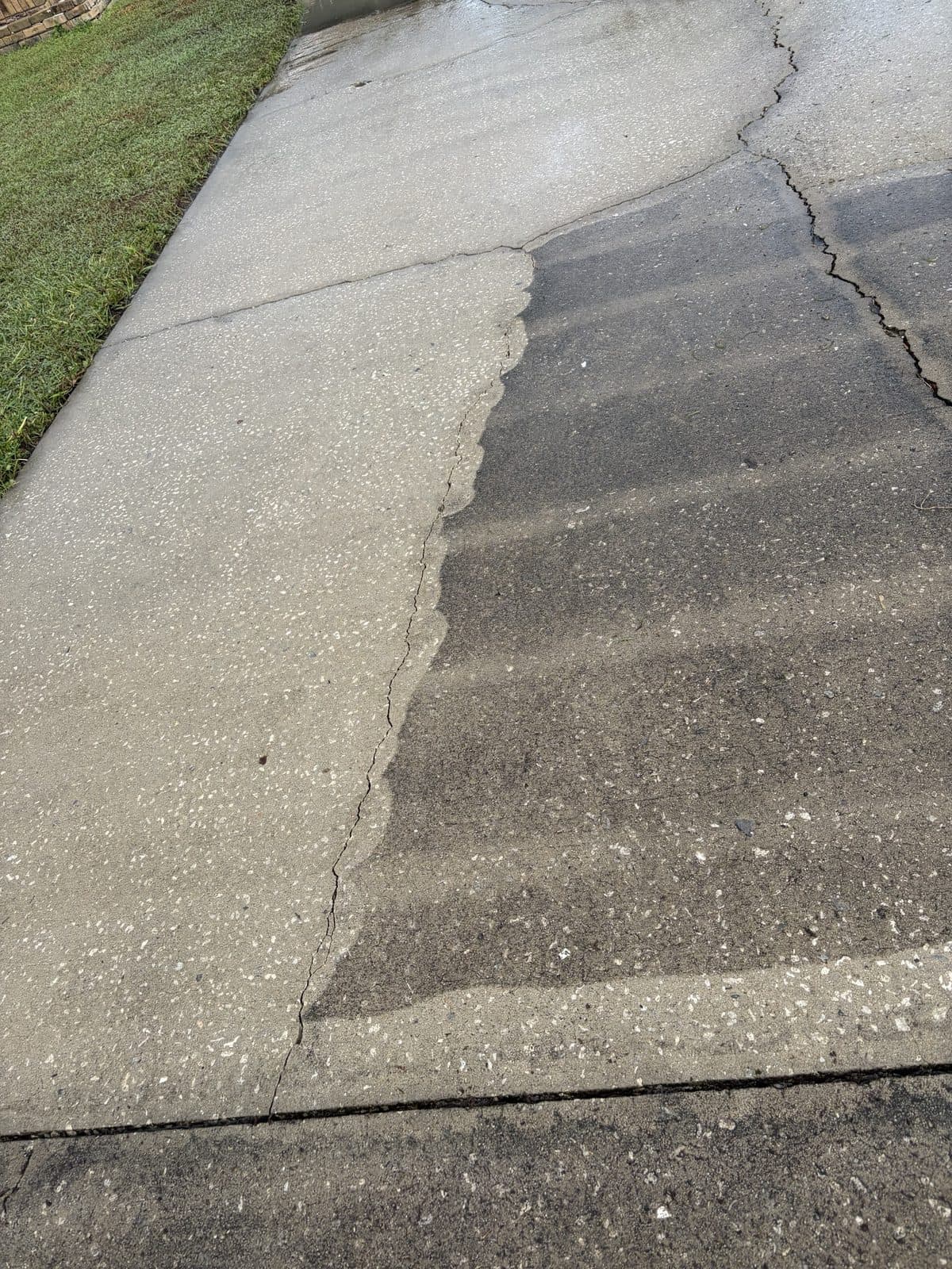 Driveway halfway through pressure washing, clean concrete beside dirty concrete, Tampa FL