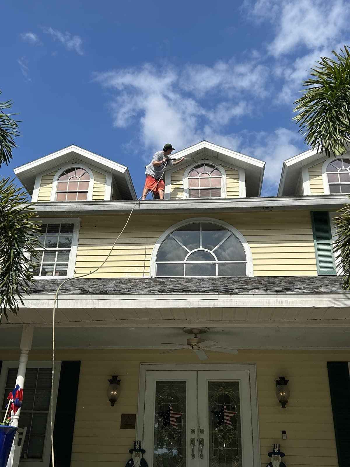 Pressure washing a two-story home's roof and dormers in Tampa Bay FL, Tom's Professional Power Wash Plus